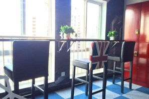 A room with a window, a table, and chairs. There are potted plants on the windowsill. - Jihe Light Luxury Art Hotel(Wuyi Square Station) (Changsha)