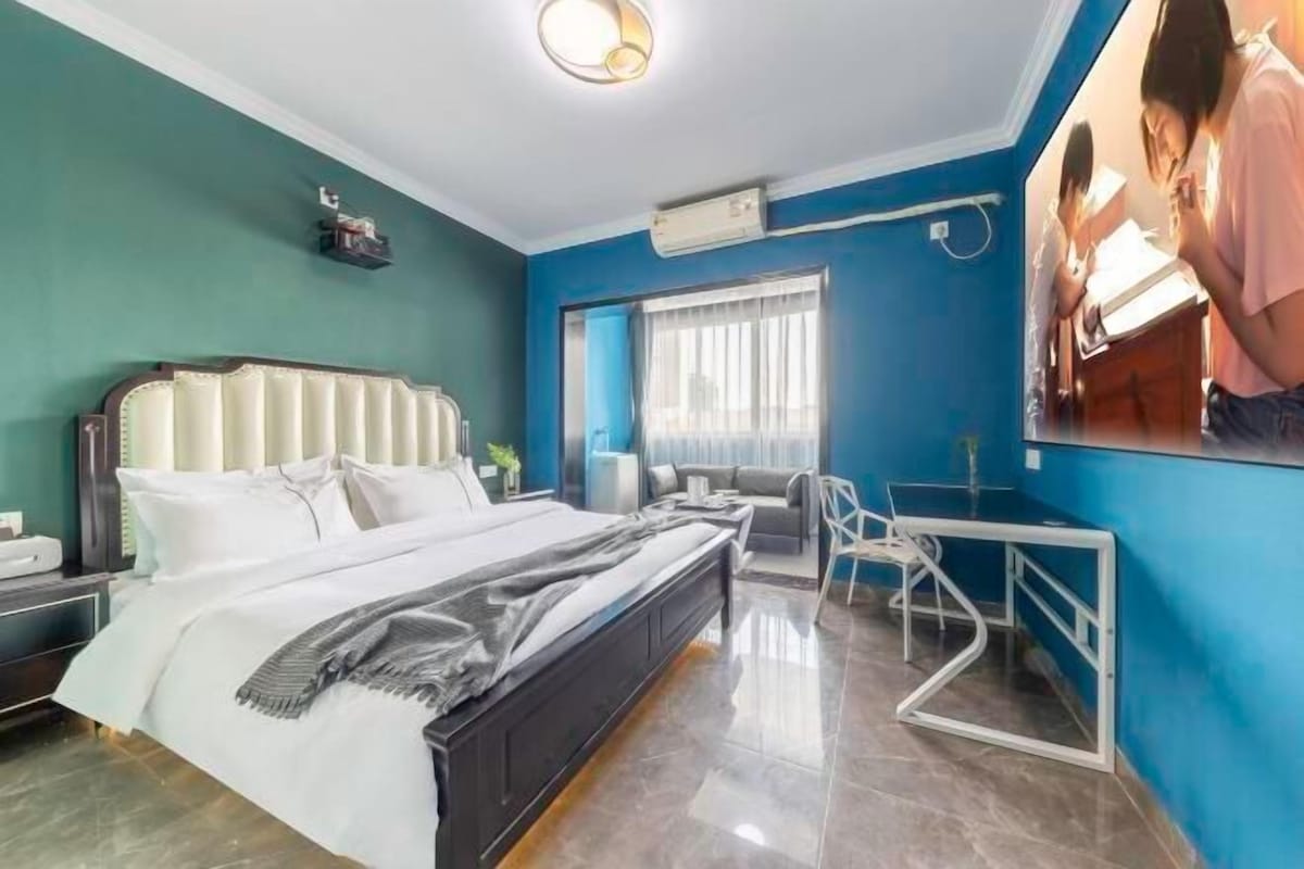 A bedroom with a bed, a desk, and a chair.