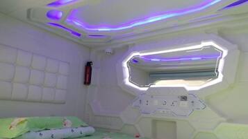 A room with a bunk bed, a window with a view, and a control panel.