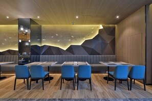Un restaurant avec des banquettes et des tables, un plancher en bois et un design moderne.