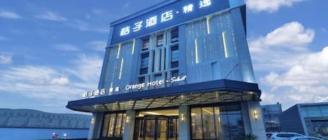 A hotel with a modern design, featuring a prominent entrance and signage.