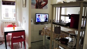 Un espacio habitable compacto con comedor, televisión y kitchenette.