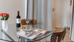 A glass table with a wine bottle, a bowl of pasta, and an open magazine. - Balcone sul Verde - Sweet Dreams in Florence (Firenze)