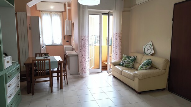 Un espacio habitable compacto con comedor, sofá y kitchenette.