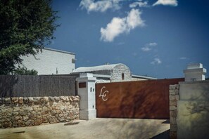 Un bâtiment moderne avec un mur en pierre et un portail en métal.