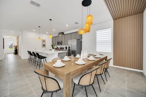 A modern kitchen with grey cabinets, a stainless steel refrigerator, and a microwave.