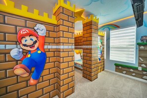 Une pièce avec un mur en briques décoré sur le thème de Mario et une grande fenêtre.