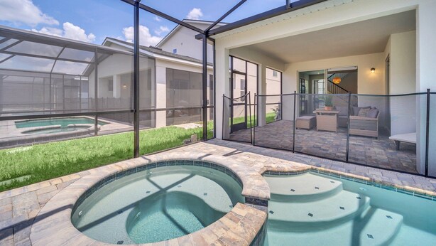 Un área de piscina exterior moderna con cerramientos de vidrio, un jacuzzi y un patio con mobiliario de exterior.