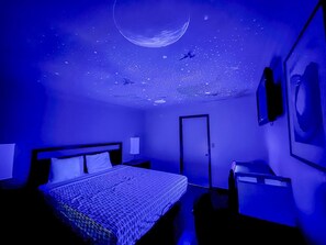 A room with a bed, a desk, and a door. - Super 7 Motel  (Anaheim)