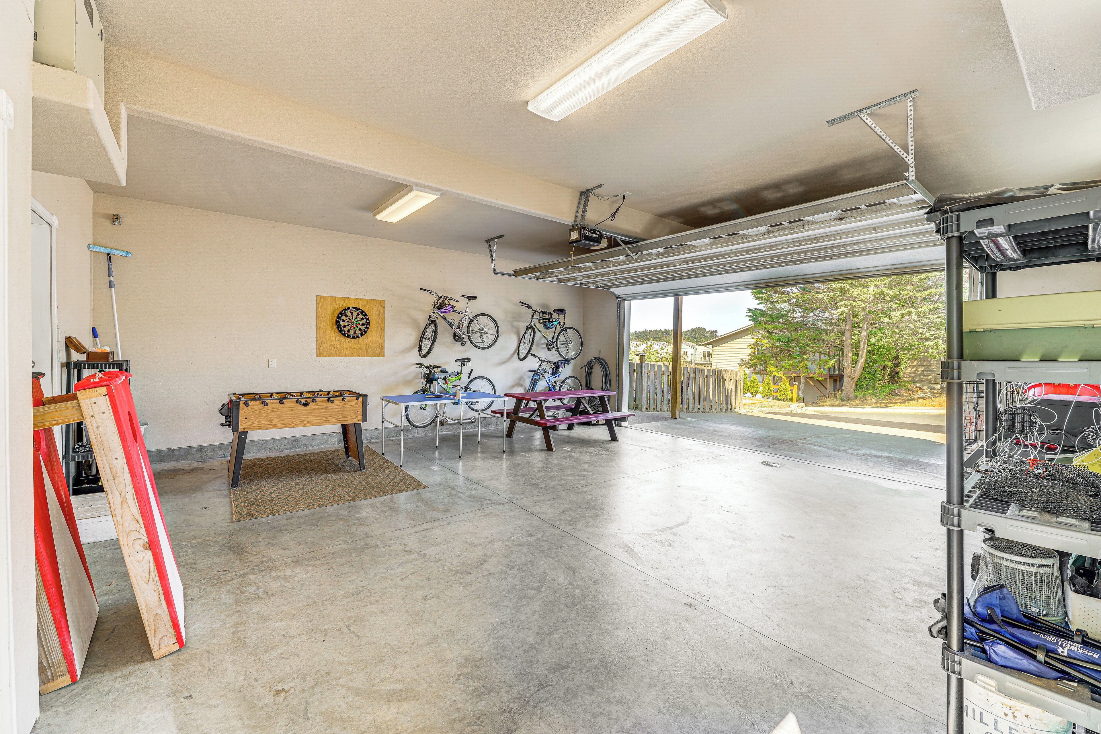 Een garage met fietsen, een tafelvoetbalspel en een dartbord.