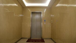 A modern elevator in a hallway with a ceiling light fixture and a doormat at the entrance. - Homeinn Pebble Hotel (Shanghai Cao'an Textile Market Dingbian Road Subway Station) (Shanghai)