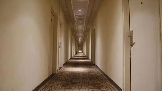 A long, narrow hotel corridor with doors on both sides, a patterned carpet, and a ceiling with recessed lighting. - Homeinn Pebble Hotel (Shanghai Cao'an Textile Market Dingbian Road Subway Station) (Shanghai)