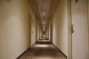 A long, narrow hotel corridor with doors on both sides, leading to individual rooms. - Homeinn Pebble Hotel (Shanghai Cao'an Textile Market Dingbian Road Subway Station) (Shanghai)
