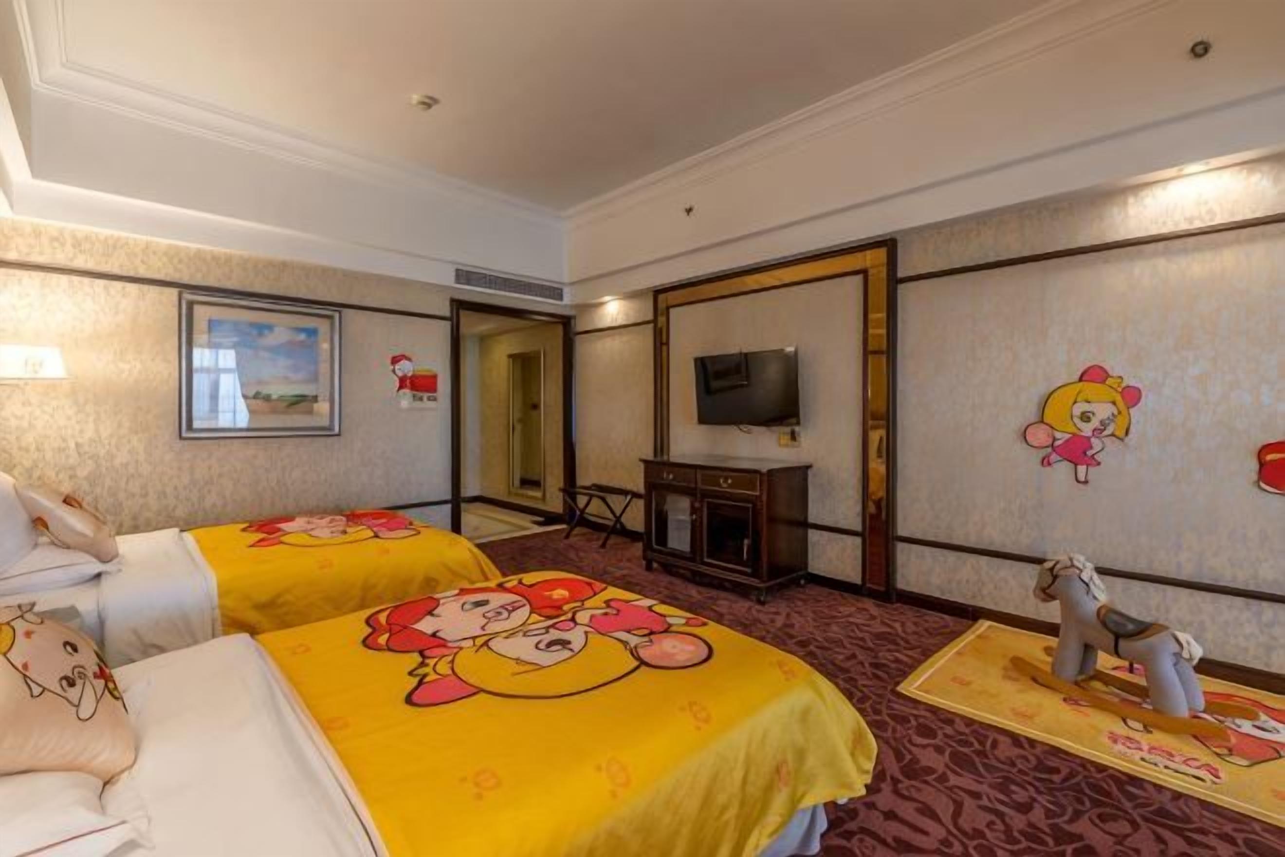 Hotellihuone, jossa on kaksi sänkyä, televisio ja peili.