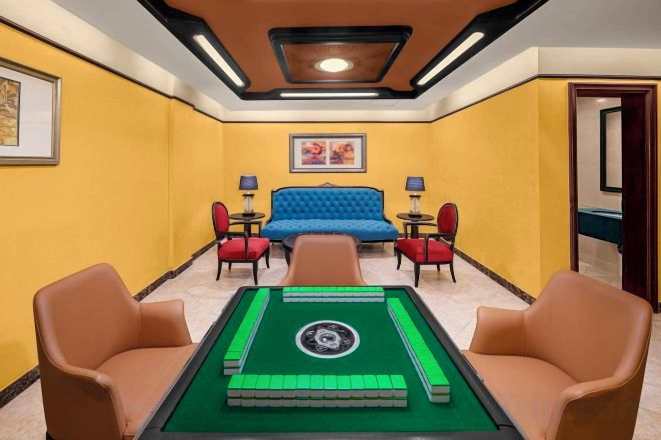 A room with a pool table, a blue sofa, and two armchairs.