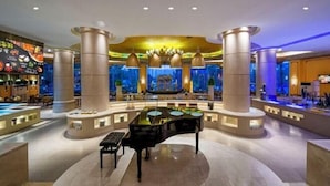 Un'elegante hall con un pianoforte a coda, un'area bar e una grande vasca per pesci.