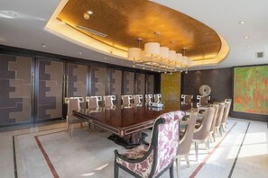 A modern dining area with a long table, chairs, and a chandelier. - Jiangyan Hotel (Taizhou)