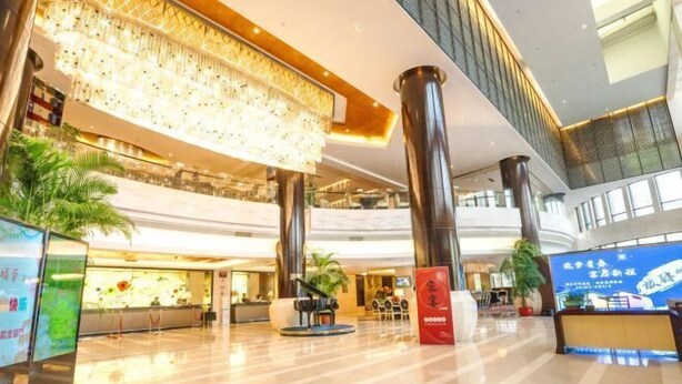 A spacious lobby with a high ceiling, large columns, and a modern reception desk. - Jiangyan Hotel (Taizhou)