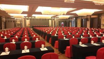 A conference room with rows of tables and chairs, equipped with nameplates and water pitchers.
