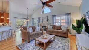 A spacious living room with two sofas, a coffee table, and a fireplace. - Walk to the Beach with Pool and Game Room (Myrtle Beach)