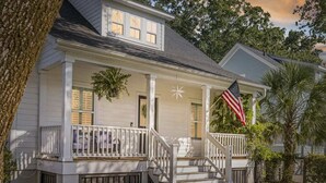 A two-story house with a porch, a flag, and a star decoration. - Cozy Charleston Home with Putting Green (N. Charleston)