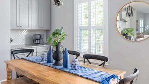 A dining area with a wooden table, chairs, and a hanging light fixture. - Cozy Charleston Home with Putting Green (N. Charleston)