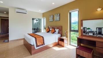 Un dormitorio moderno con una cama grande, una mesita de noche de madera, un escritorio y un espejo amplio.