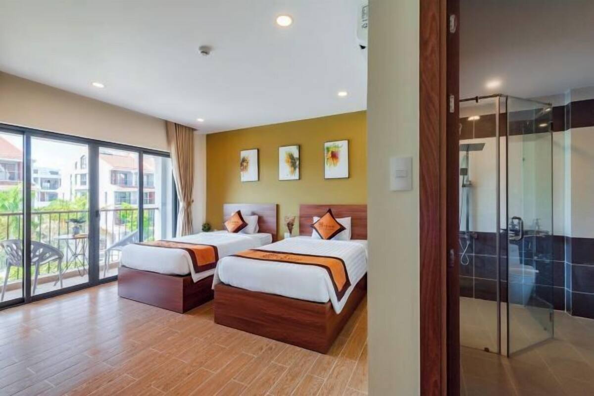 Une chambre d’hôtel avec deux lits, un balcon et une douche en verre.