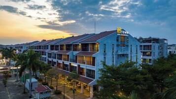 Un hotel con diversi piani, un logo 'M' ben visibile e un cartello che indica 'Hotel & Residences'.