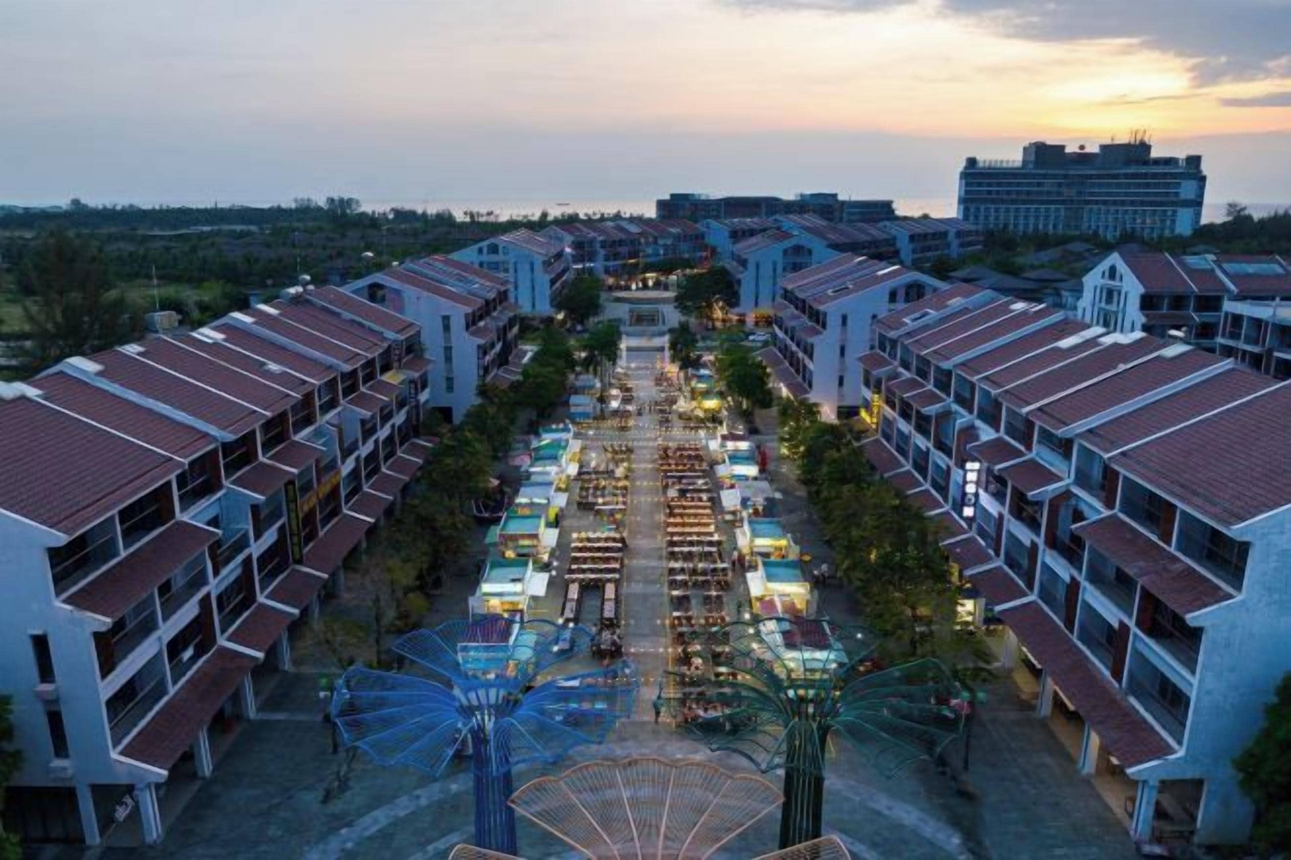A hotel with multiple buildings, a central courtyard, and a view of the surrounding area.