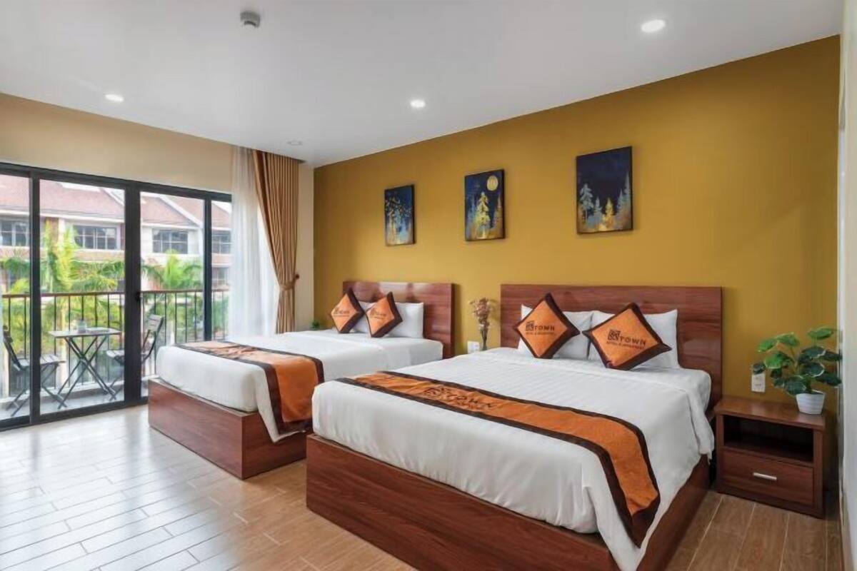 Une chambre d’hôtel avec deux lits, un balcon et des œuvres d’art accrochées au mur.