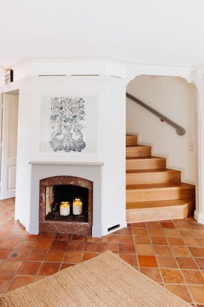 Una escalera con una pared blanca y una chimenea con dos velas.