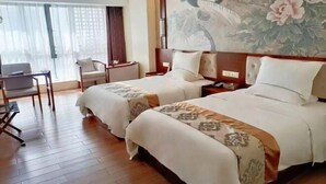 A hotel room with two beds, a desk, a chair, and a large window with curtains. - Guanhai Holiday Hotel (Lufeng)