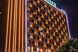 A multi-story hotel with illuminated windows and a sign in a foreign language. - Guanhai Holiday Hotel (Lufeng)