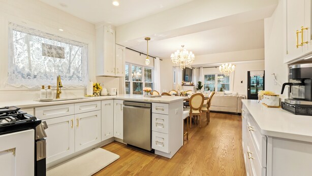 A modern kitchen with white cabinetry, a central island, a dishwasher, and a stove. - French Country Cottage in lovely Glen Ellyn! (Glen Ellyn)