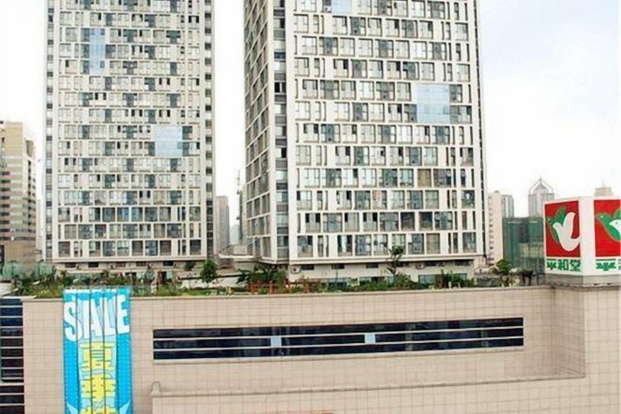 A high-rise building with multiple floors, large windows, and a prominent sign with Chinese characters.