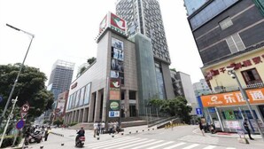 A modern urban street with high-rise buildings, a prominent commercial building with multiple signs, and a crosswalk. - Qinqinwojia Apartment (Changsha Dongyi International) (Changsha)