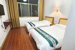 Quarto de hotel com duas camas, televisão na parede, janela com cortinas e piso de azulejos.