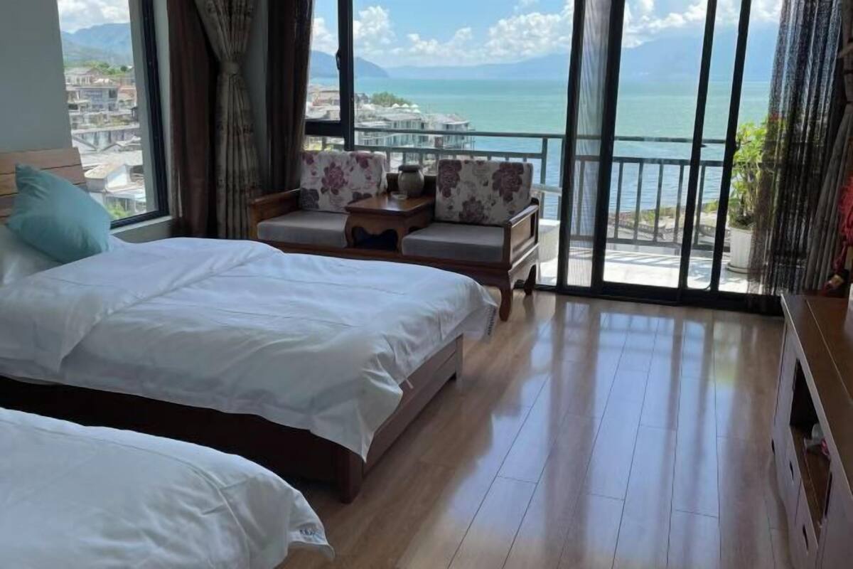 A hotel room with a bed, a sofa, and a view of the sea.