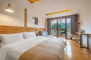 A hotel room with a large bed, a desk, a chair, and a view of the outdoors.