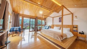 A bedroom with a four-poster bed, a desk with a chair, and a table with a tablecloth. - Zhaoxing Dong Village at that time, flowers blossoming, live music, courtyard homestay (Liping)