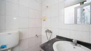 A bathroom with white tiled walls, a white sink, a black countertop, and a mirror with a floral design. - Chenzhou Junhao Hotel (Chenzhou)