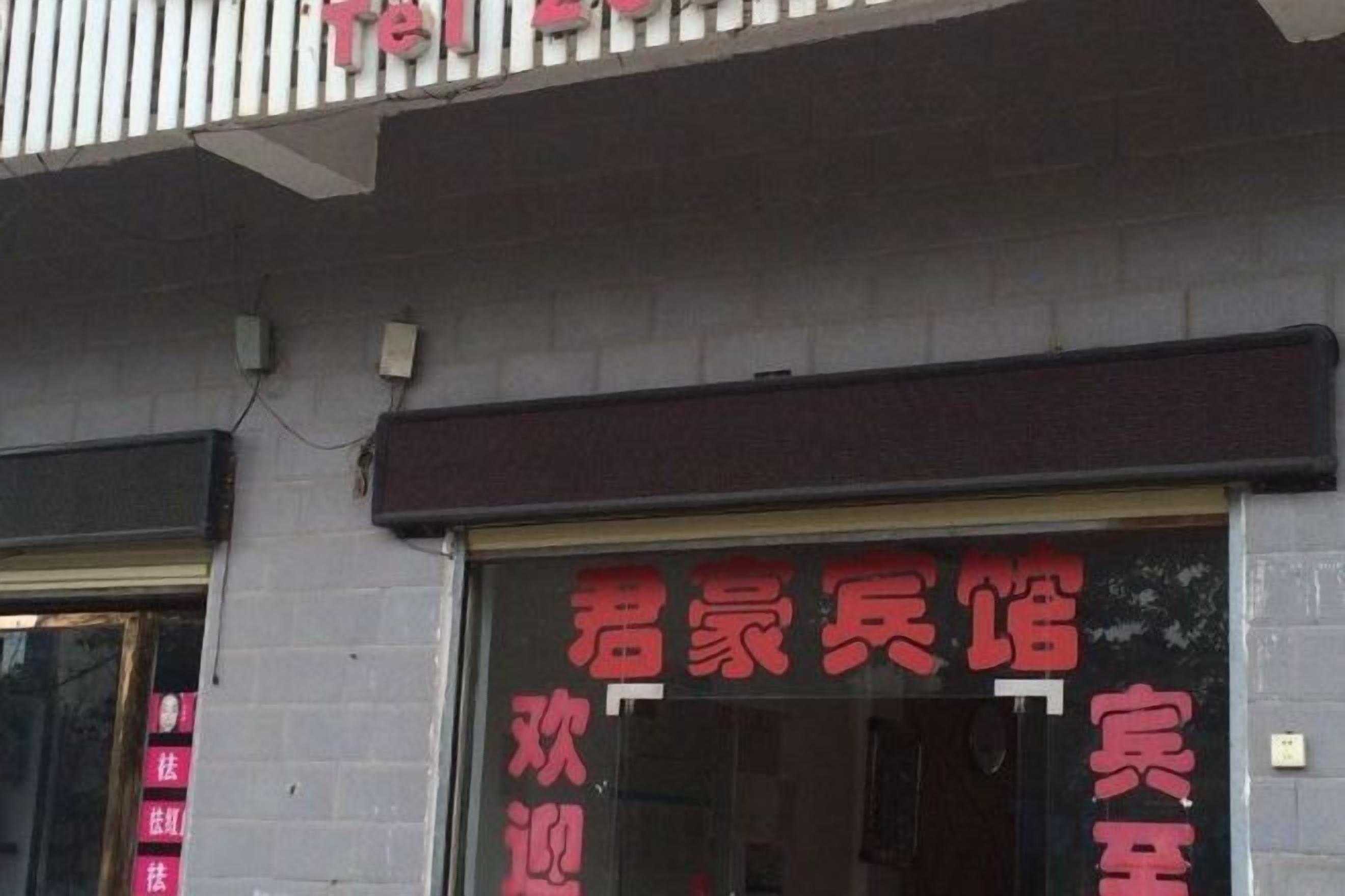 Fachada de un edificio con un amplio ventanal que muestra texto rojo, posiblemente un letrero o anuncio.