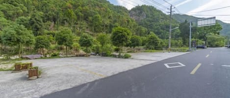 A road with a parking area and a mountain backdrop.