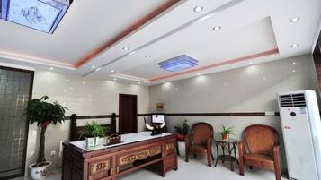 A modern office with a desk, chairs, and a large air conditioning unit.