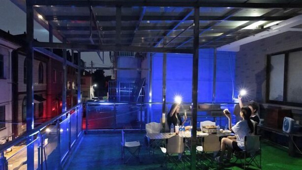 Un espace intérieur doté d’une cloison en verre, de tables, de chaises et d’un sol recouvert d’une moquette verte.