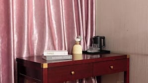 Un bureau en bois sur lequel se trouve un livre intitulé « TROIS STYLES MODERNES », un vase décoratif, une machine à café noire et un plateau avec des verres.
