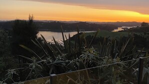 Vista di un lago al tramonto, con una recinzione in primo piano.