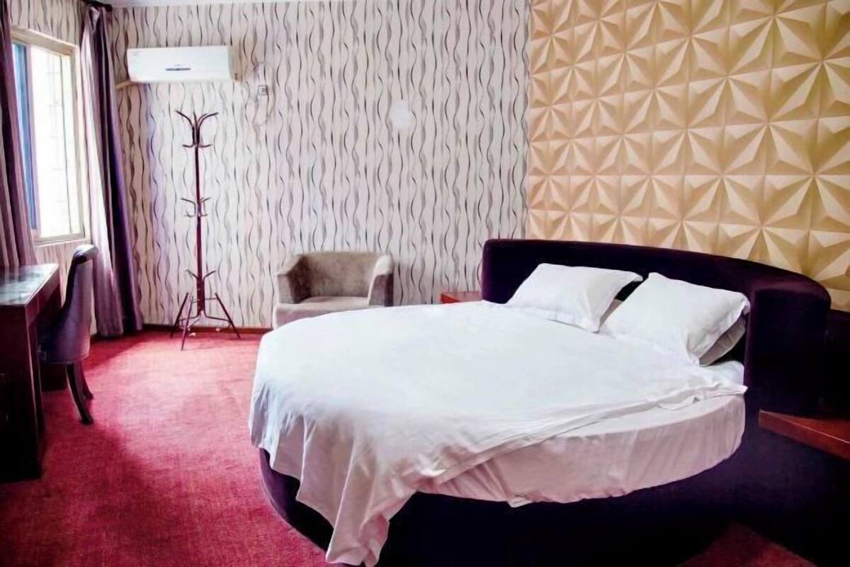 Una habitación de hotel con una cama, un escritorio y una silla.