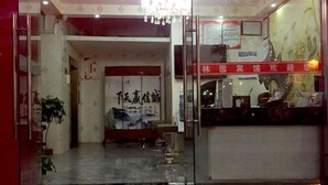 A hotel reception area with a glass door, a reception desk, and a chandelier. - Linyuan Hotel (Jinhua)